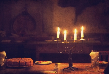 Retro candle and cake on table. Photo in old vintage style.