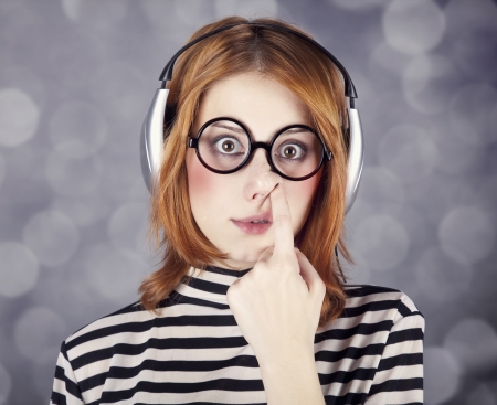 Funny girl with headphone and glasses. Studio shot.の写真素材