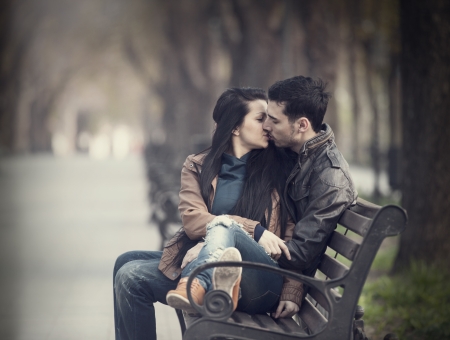 Couple kissing at the bench at alley.の写真素材