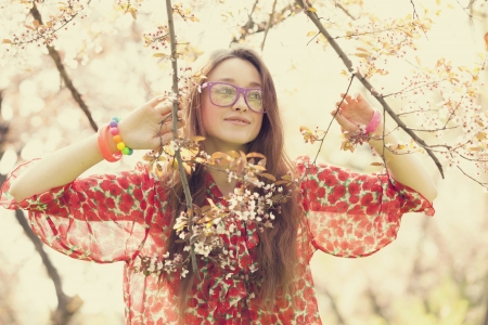 Teen girl in glasses near blossom treeの写真素材