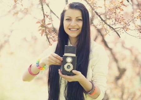 Beautiful girl with camera in spring park.の写真素材