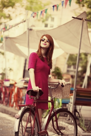 Redhead girl with bike at outdoor, city. の写真素材