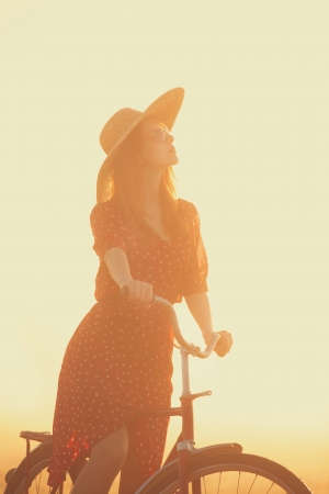 Girl on a bike in the countryside in sunrise time.の写真素材