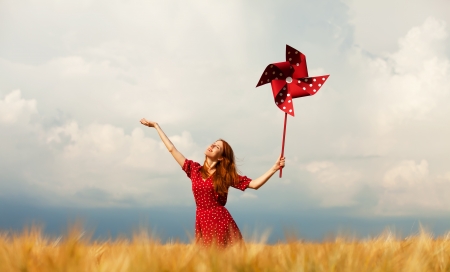 Redhead girl with toy wind turbineの写真素材