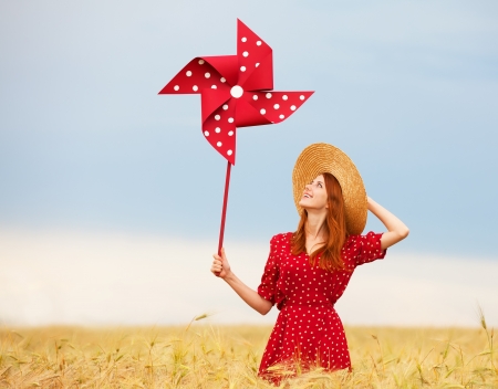 Redhead girl with toy wind turbineの写真素材