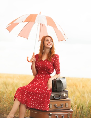 Redhead girl with suitcases at outdoorの写真素材