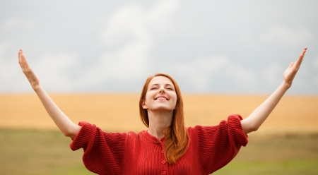 Redhead girl at meadow near wheat fieldの写真素材