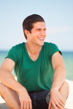 Handsome young man at beach backgroundの写真素材