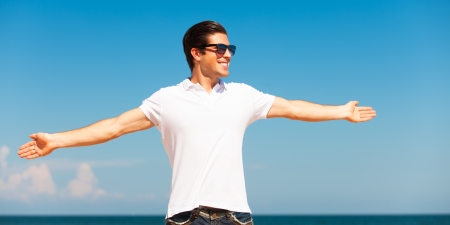 Handsome young man at beach backgroundの写真素材