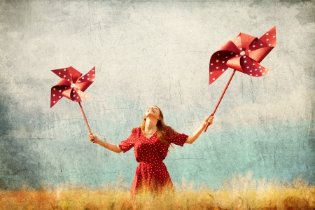 Redhead girl with toy wind turbineの写真素材