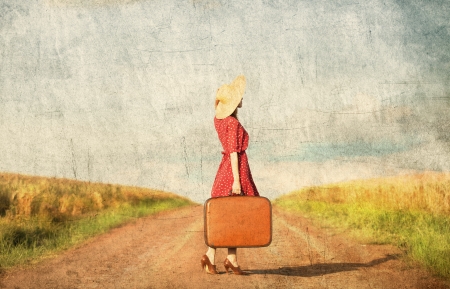 Redhead girl with suitcase at outdoor.の写真素材