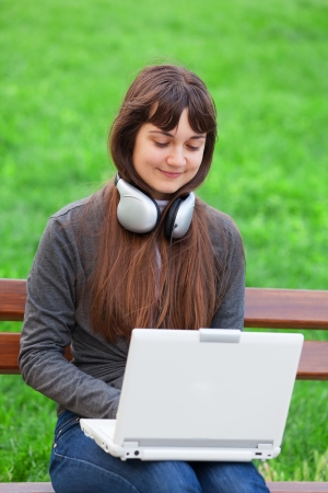 Brunette girl sitting at the bench with notebookの写真素材