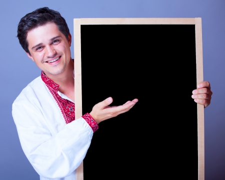 Handsome man in national embroidery with blackboard.の写真素材