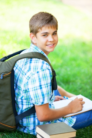 Teen boy with books and notebook at outdoor.の写真素材