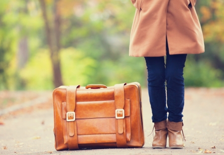 Women's foots near suitcase at autumn outdoor.の写真素材