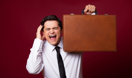Man with case at red background