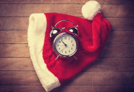 Retro alarm clock on table with christmas hatの写真素材