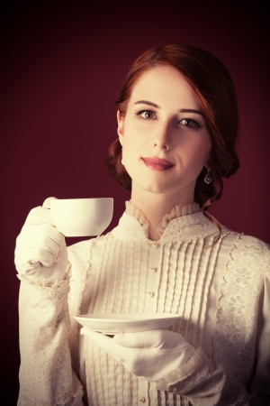 Beautiful redhead women with cup of teaの写真素材