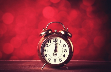 Retro alarm clock on table and red background