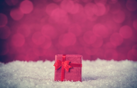 Gift box on snow and red backgroundの写真素材