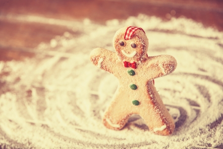 Cookie men on wooden table. Photo in old color style.