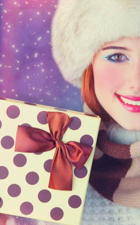 Beautiful redhead women with gift. Photo with bokeh at background.の写真素材