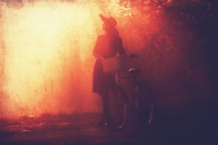 Girl on a bike in the countryside in sunrise time.の写真素材
