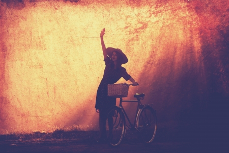 Girl on a bike in the countryside in sunrise time.の写真素材