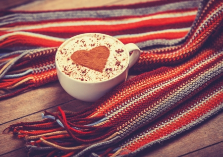 Cup with coffee and shape of the cacao heart on it and scarf. Photo with vintage vignetting.の写真素材