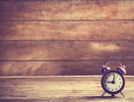 Retro alarm clock on a table. Photo in retro color image style
