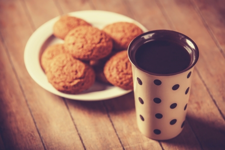 Cup of coffee and cookie. Photo in old color image style.