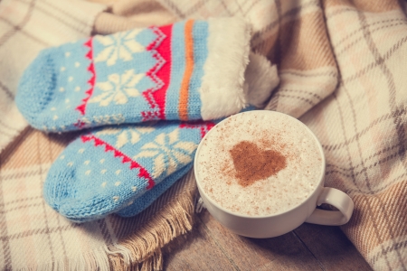 Cup with coffee and shape of the cacao heart on it and scarf. Photo with vintage vignetting.の写真素材