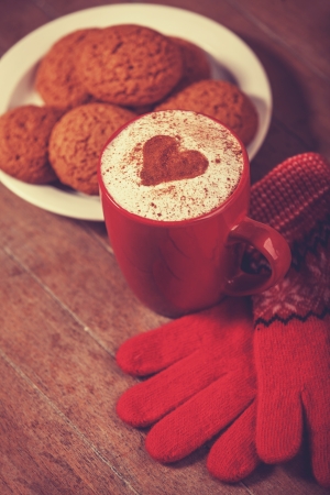 Gloves, cookie and cup with coffee. Photo with vintage styleの写真素材