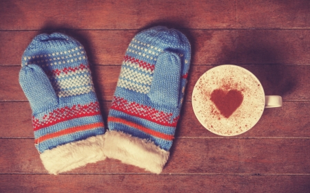 Gloves and cup with coffee and shape of the cacao heart on it. Photo with vintage styleの写真素材