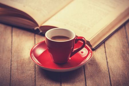 red cup of the coffee and vintage book. Photo with filter as a retro color image style.の写真素材