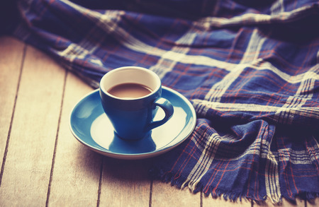blue cup of the coffee and vintage scarf. Photo with filter as a retro color image style.の写真素材