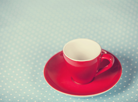 Cup of a coffe on polka dot cover. Photo in old color image style.の写真素材