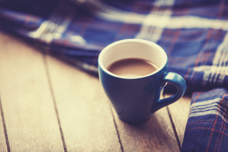 blue cup of the coffee and vintage scarf. Photo with filter as a retro color image style.の写真素材