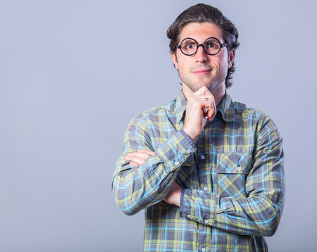 Portrait of funny man in glasses on gray background.の写真素材