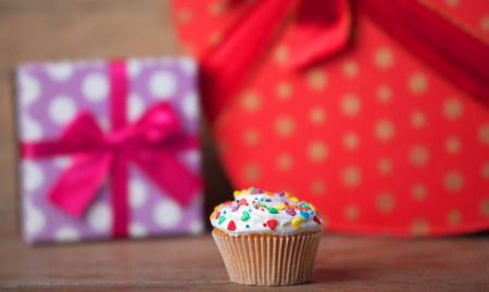 Cream cake with gifts on a wooden table.の写真素材