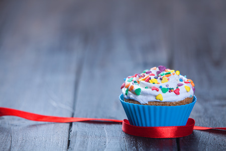 Cupcake and bow on wooden table.の写真素材