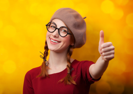 Redhead girl with pigtails on yellow background.の写真素材