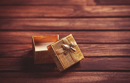 Red gift box on wooden table. Photo in retro color image style.の写真素材