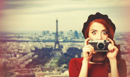 Redhead women with scarf and vintage camera on Parisian backgroundの写真素材