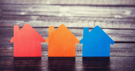 Three paper houses on wooden table.の写真素材