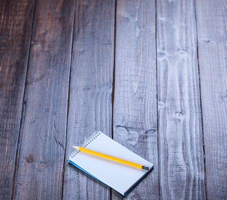 Notebook and pencil on wooden table.の写真素材