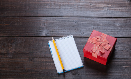 Notebook, gift and pencil on wooden table.の写真素材