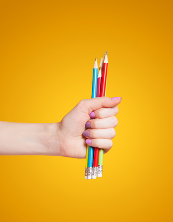 Hand holding color pencilsの写真素材