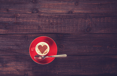 Cup of coffee with shape heart on a wooden table.の写真素材