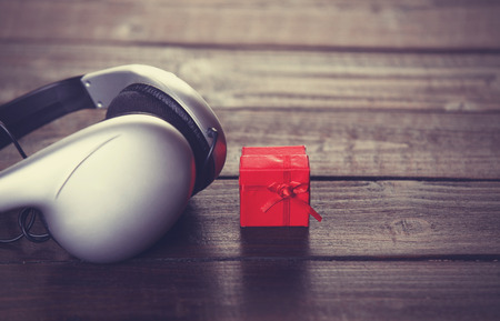 Headphones and little gift on wooden table.の写真素材
